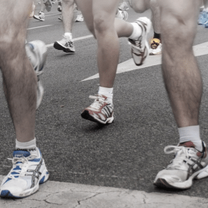 The legs of runners as they cross a finish line